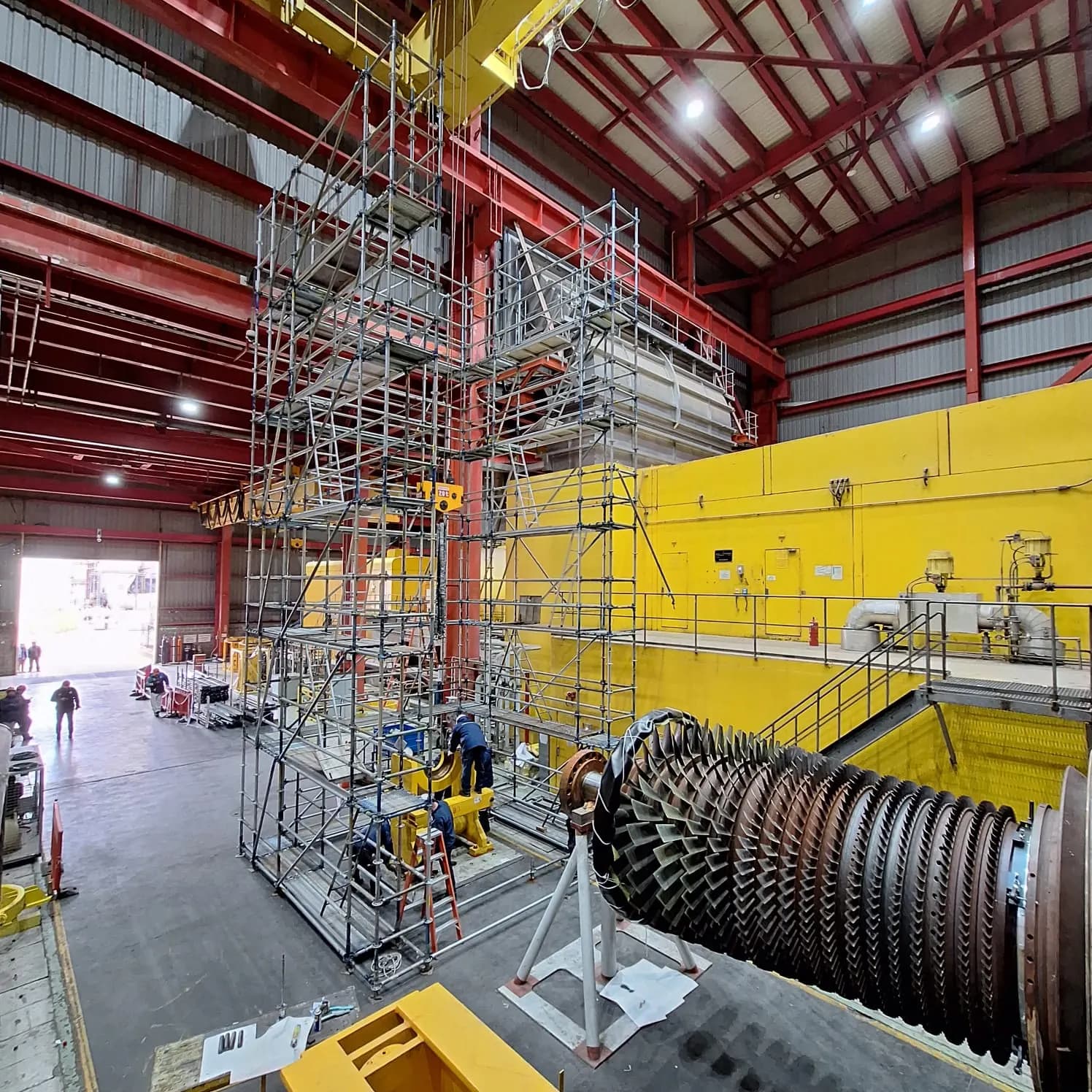 Andamios multidireccionales armados junto a una turbina en una planta industrial